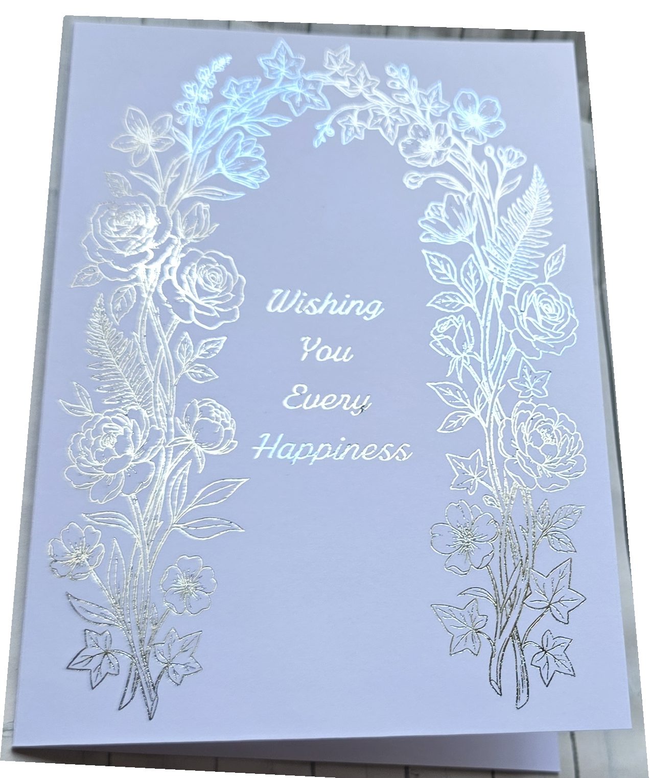 Handmade wedding card featuring a silver foil embossed floral arch with roses peonies and ferns on white card reading Wishing You Every Happiness