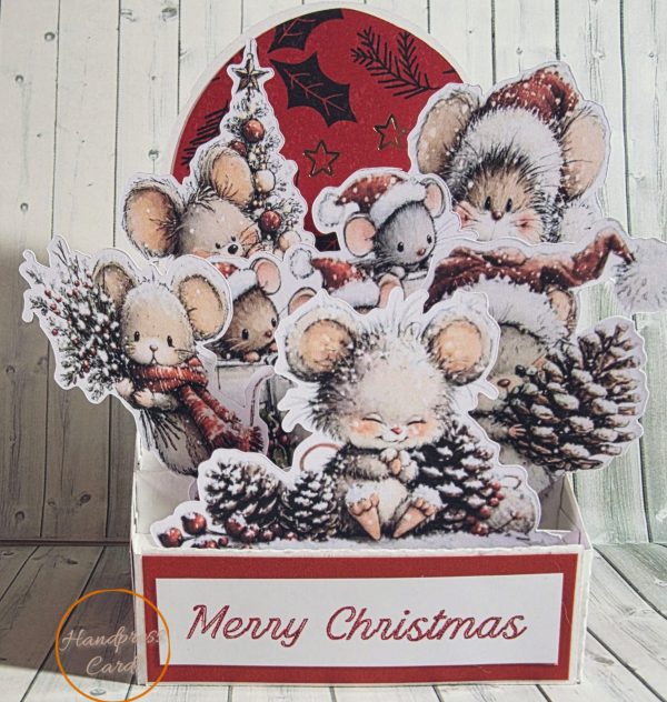 Handmade 3D decoupage Christmas card featuring layered die-cut mice in scarves and Santa hats with pinecones, holly and Christmas tree on a red foiled background with Merry Christmas sentiment