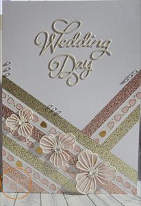 Polish_20260630_174256310 Handmade Wedding Day card with embossed cream lettering, rose gold and champagne diagonal trim, dimensional die-cut flowers and crystal embellishments on white background