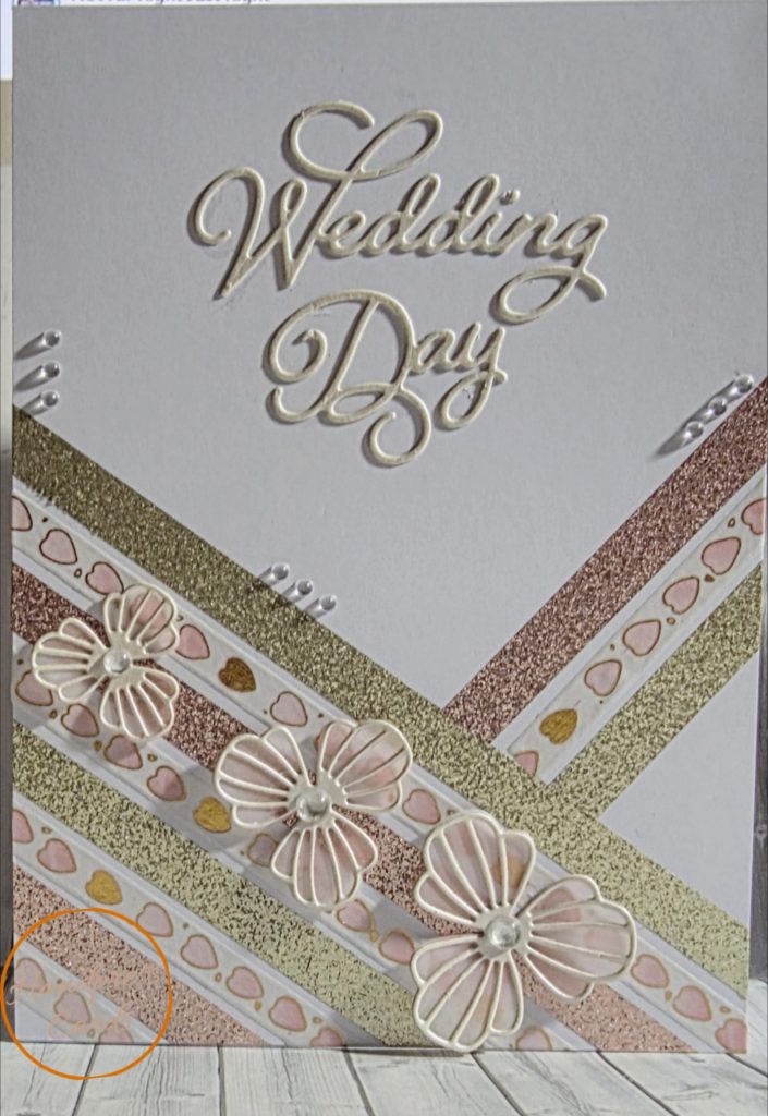 Handmade Wedding Day card with embossed cream lettering, rose gold and champagne diagonal trim, dimensional die-cut flowers and crystal embellishments on white background