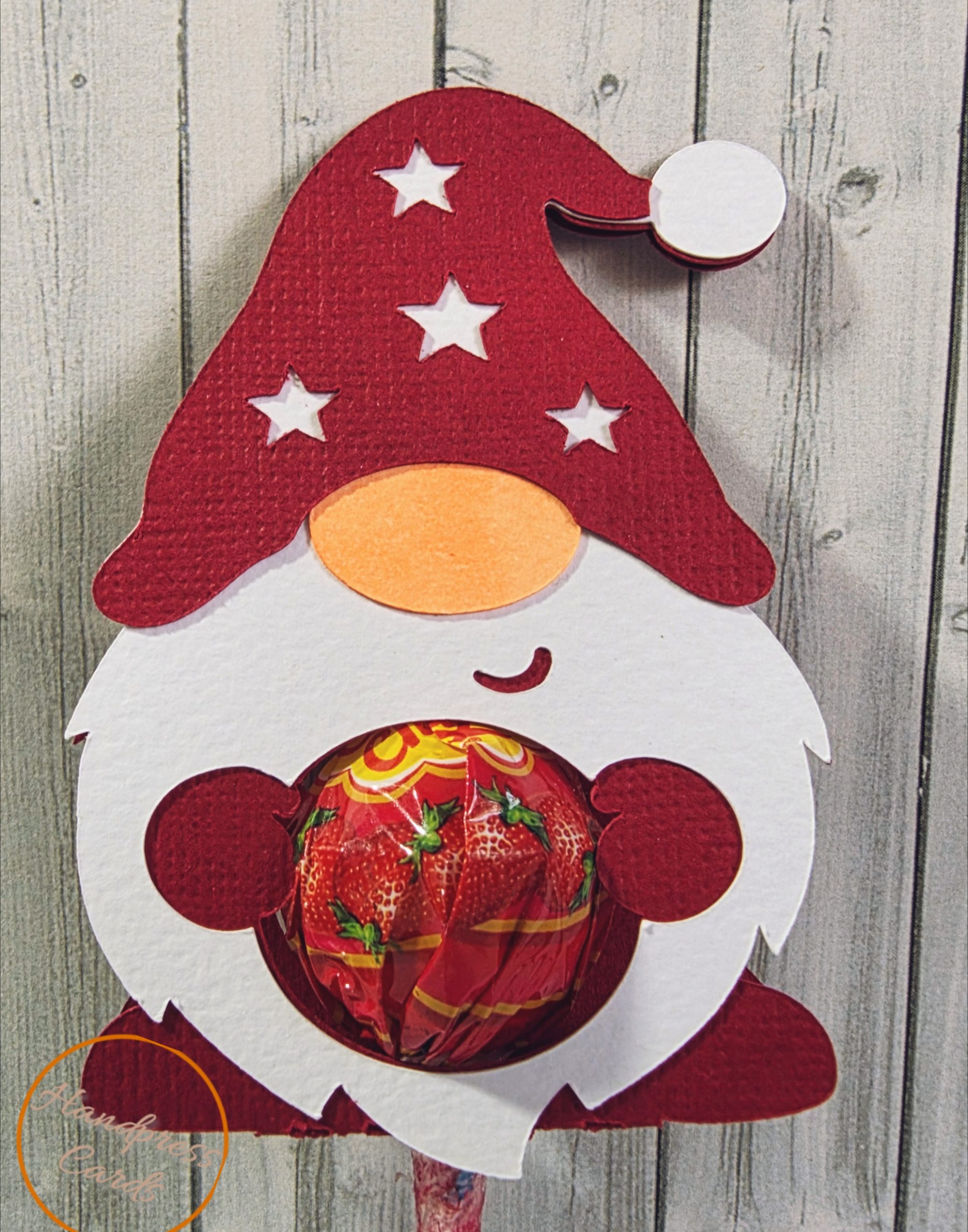 Handmade Christmas gnome lollipop holder in red and white with star-cut hat and pom-pom, by Handpress Cards