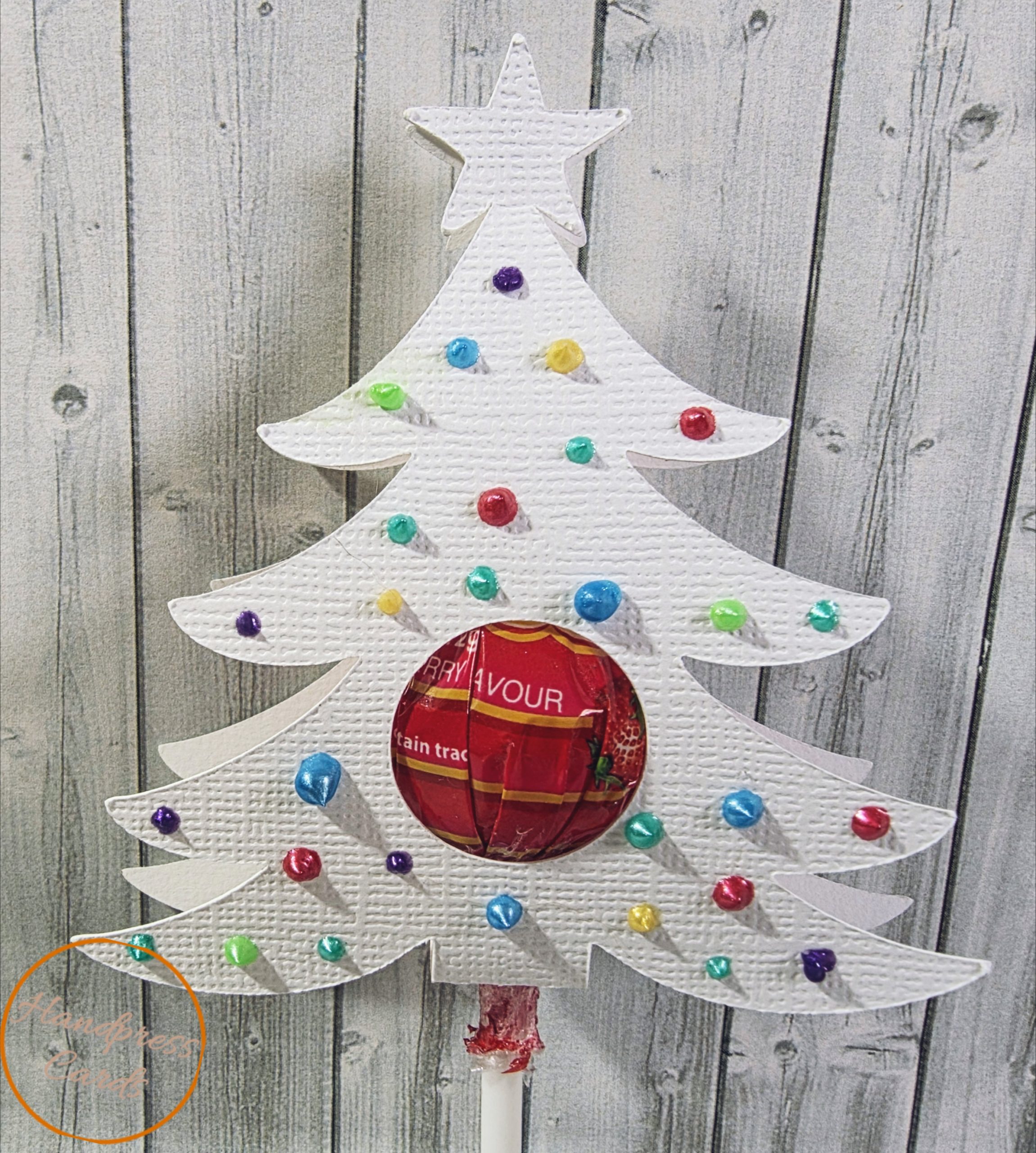 Handmade white Christmas tree lollipop holder with rainbow foiled baubles and star topper, by Handpress Cards